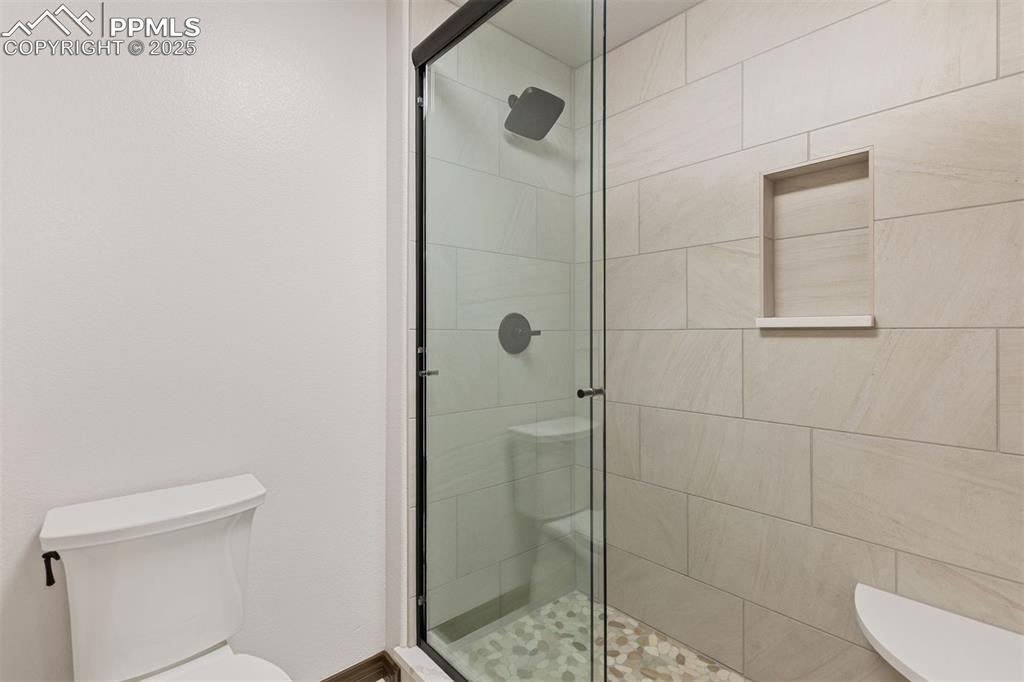 Image 46 of 50: Shower with mud-set floor and glass shower enclosure