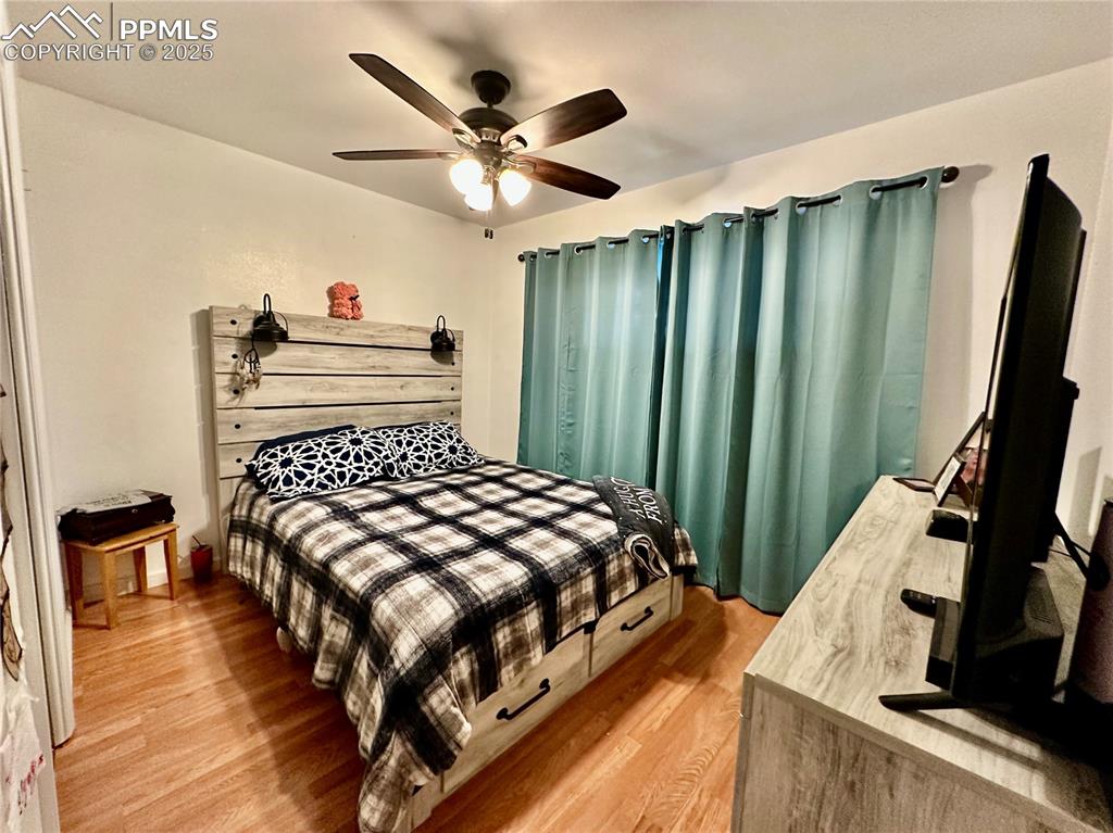 Image 11 of 20: Bedroom with light wood-style floors and a ceiling fan