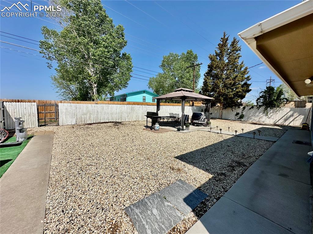 Image 16 of 20: Fenced backyard featuring a gazebo and a patio area