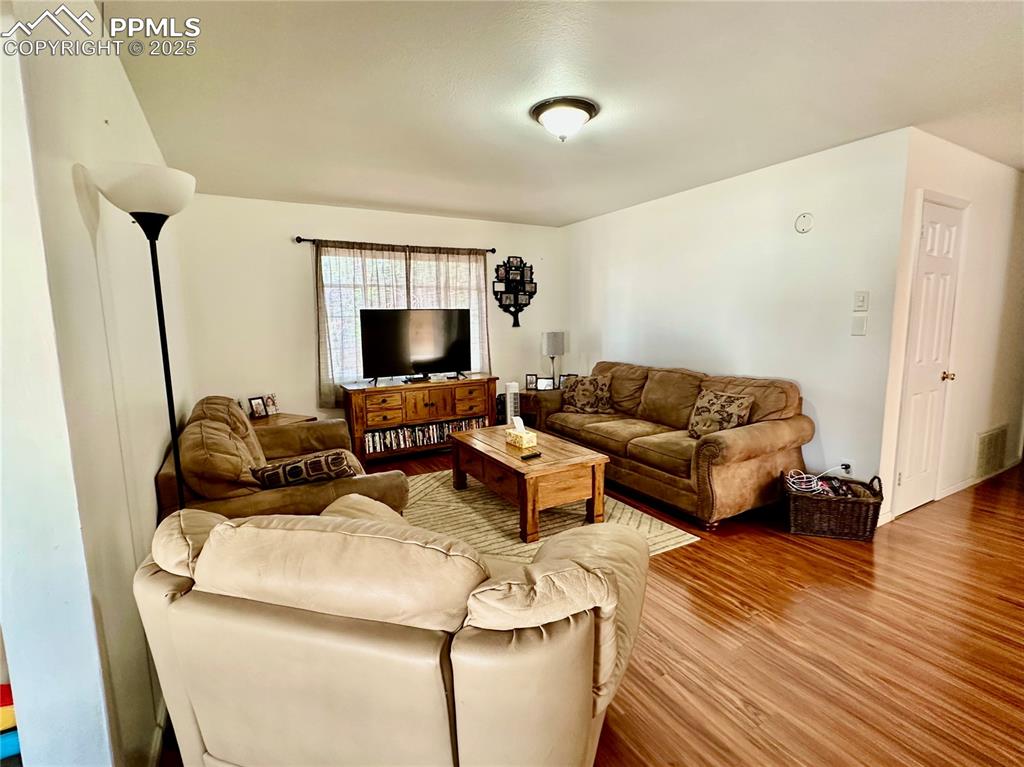 Image 4 of 20: Living area with wood finished floors