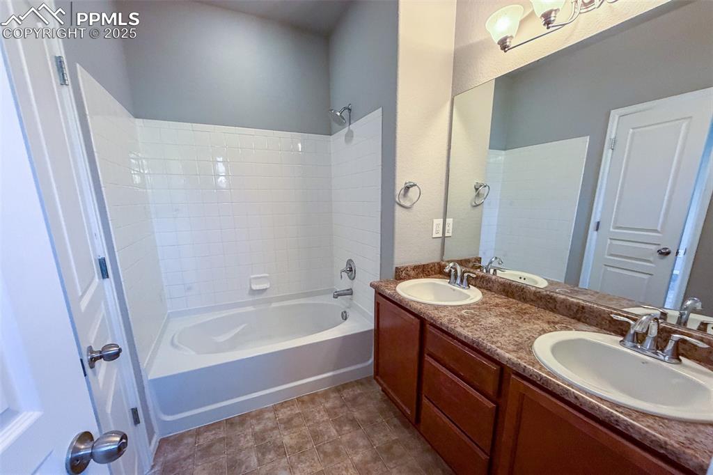 Image 15 of 22: Full Primary bath with double sinks and water closet