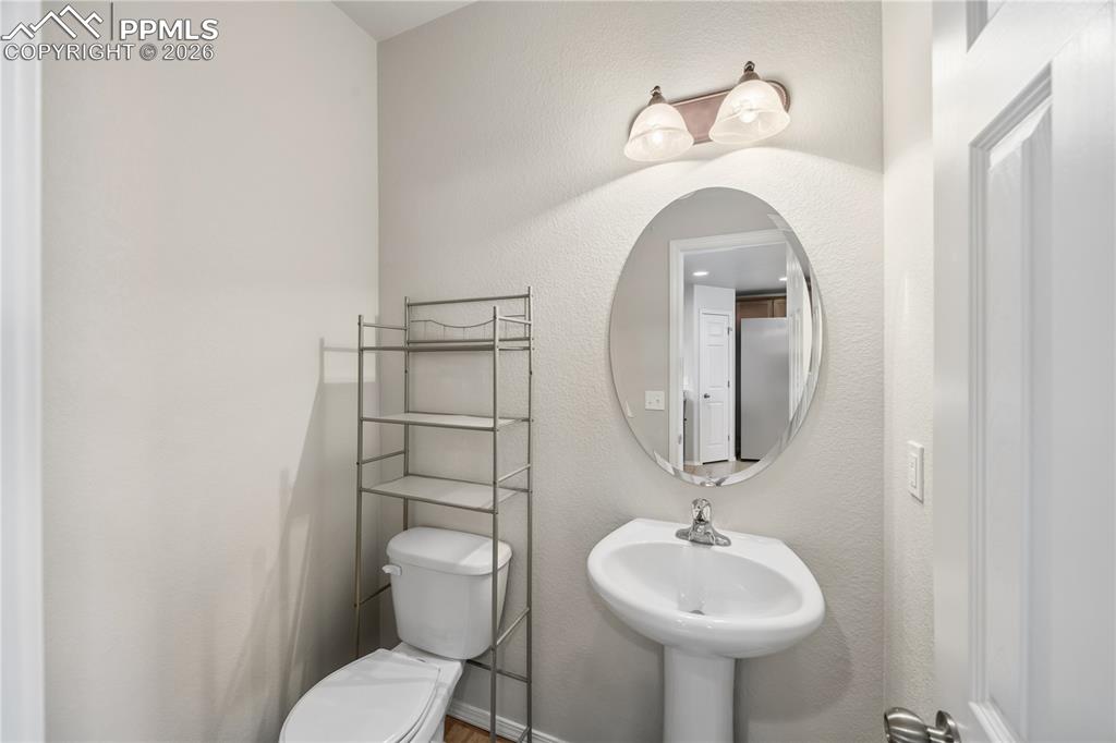 Image 13 of 30: Convenient Powder Bathroom with pedestal sink.
