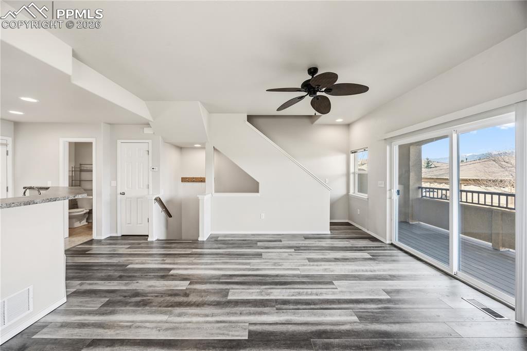 Image 14 of 30: Living Room with stairs to the upper level and basement.