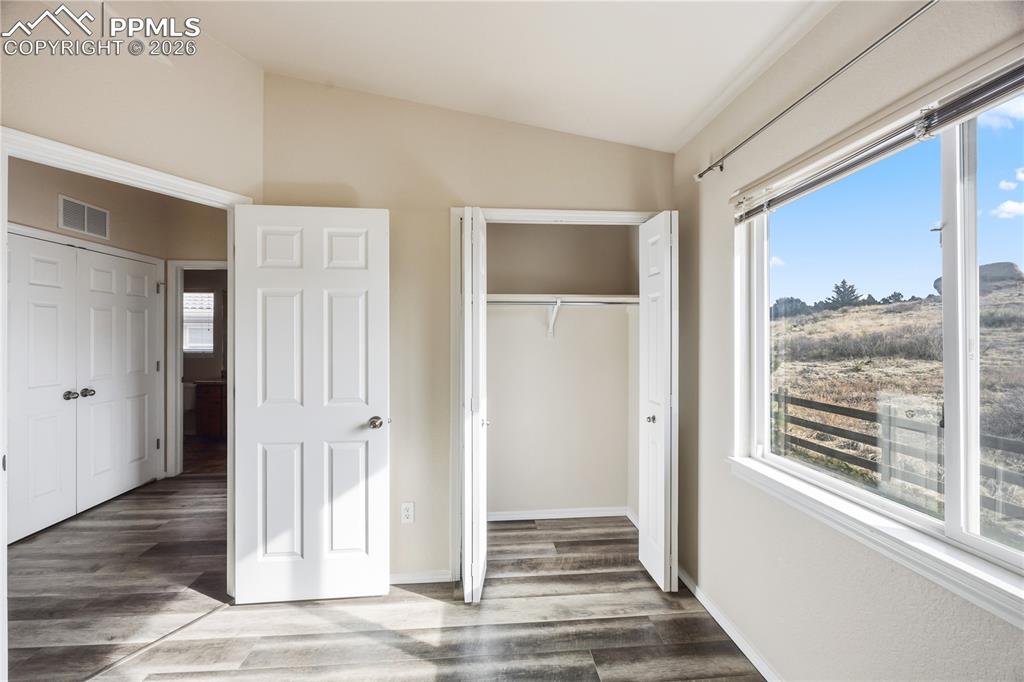 Image 18 of 30: Bedroom #2 has a deep closet and view window to the backyard with window bl