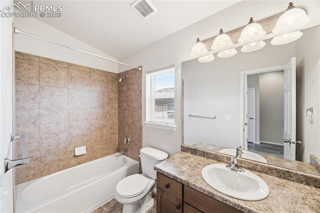 Image 19 of 30: Full Hall Bathroom with vanity, mirror, and tiled tub/shower