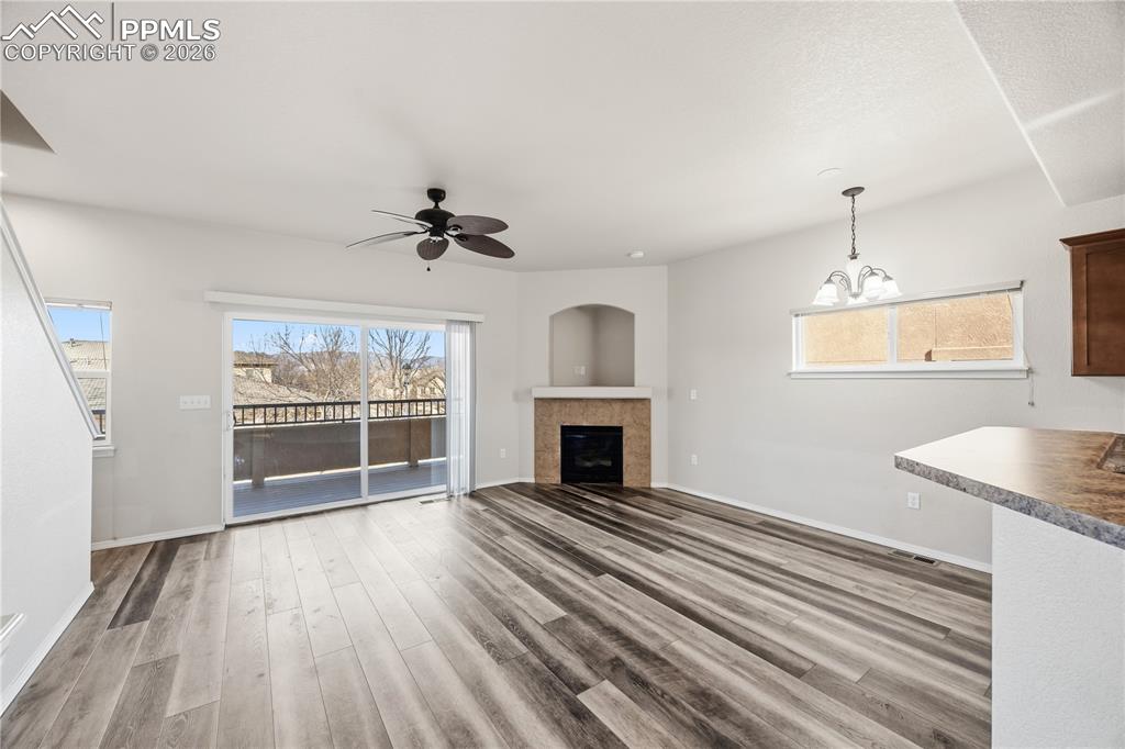 Image 4 of 30: The Living Room features a ceiling fan, LVP flooring, a gas fireplace with 