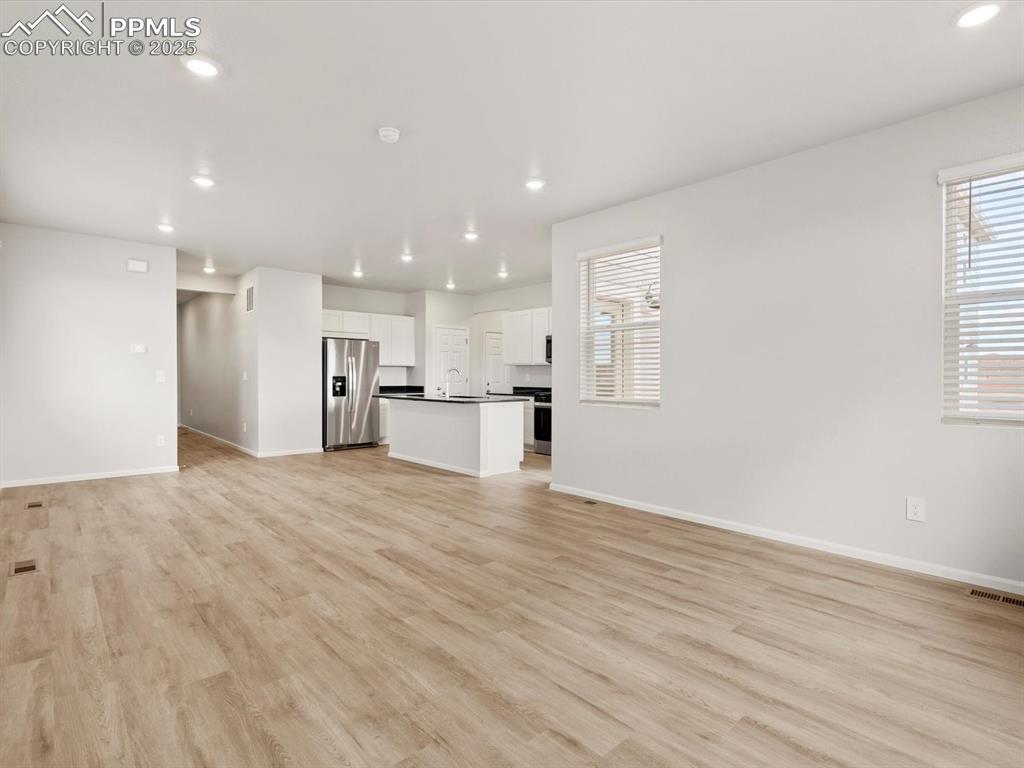 Image 10 of 23: Unfurnished living room with recessed lighting and light wood-type flooring