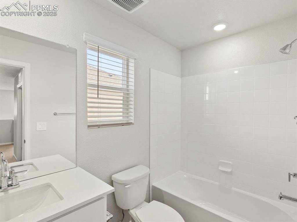 Image 16 of 23: Bathroom with shower / washtub combination, vanity, and a textured wall