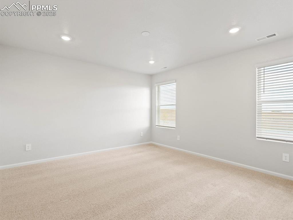 Image 18 of 23: Empty room with light carpet and recessed lighting