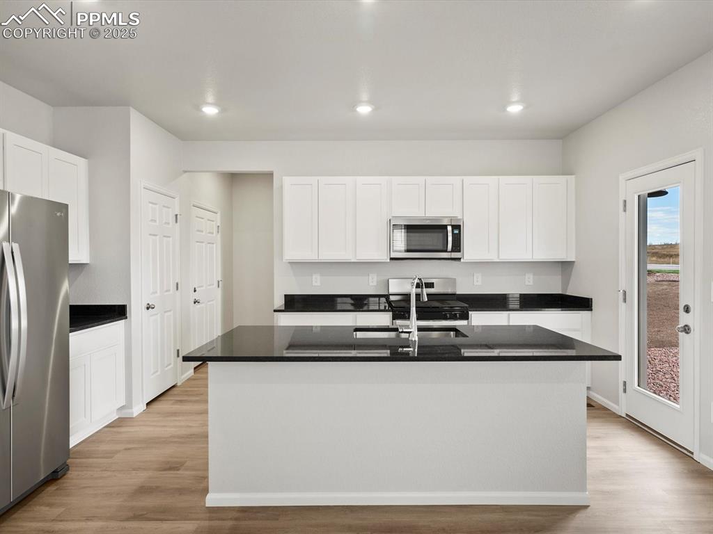 Image 2 of 23: Kitchen featuring light wood finished floors, white cabinetry, stainless st