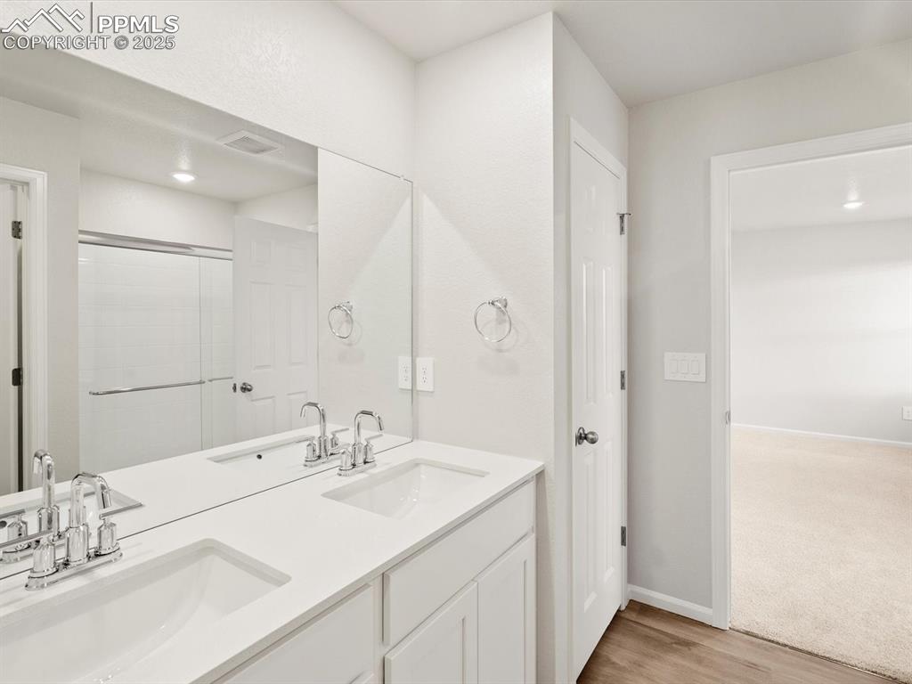 Image 21 of 23: Bathroom with a stall shower, double vanity, and light wood-style floors
