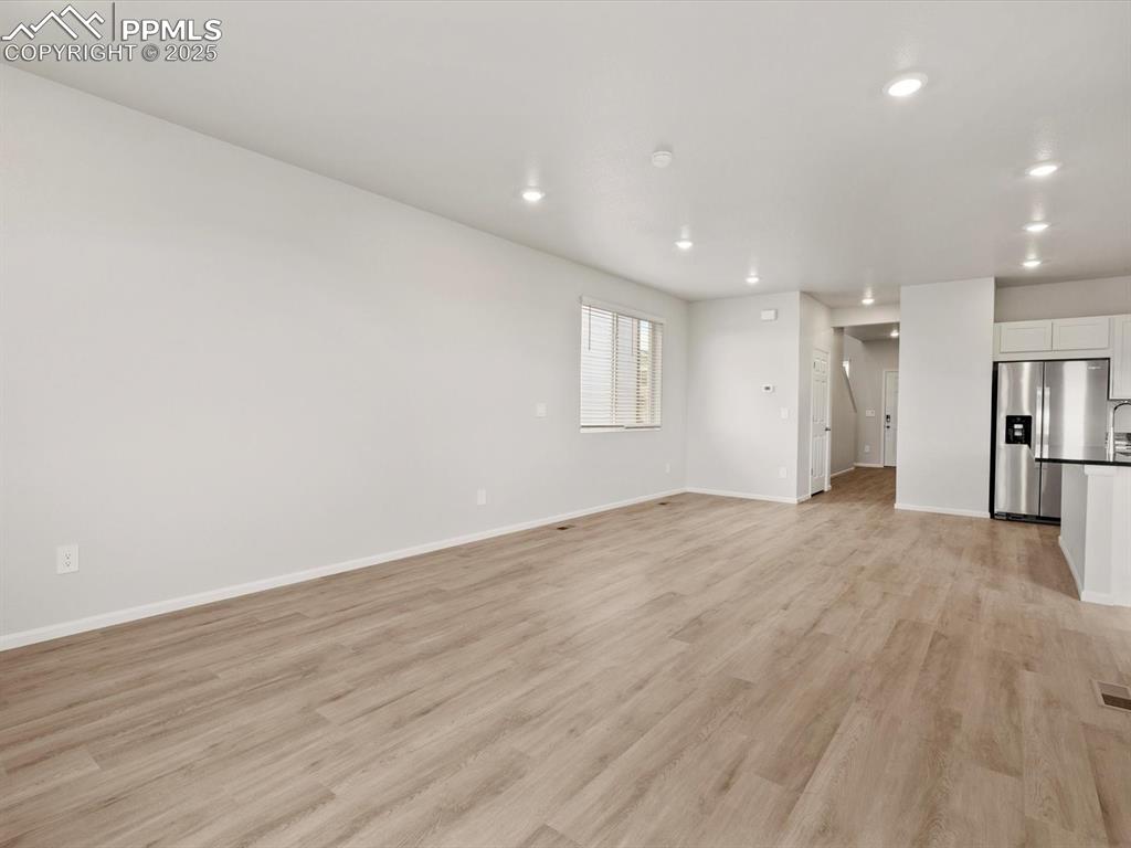Image 9 of 23: Unfurnished living room featuring light wood-style floors and recessed ligh