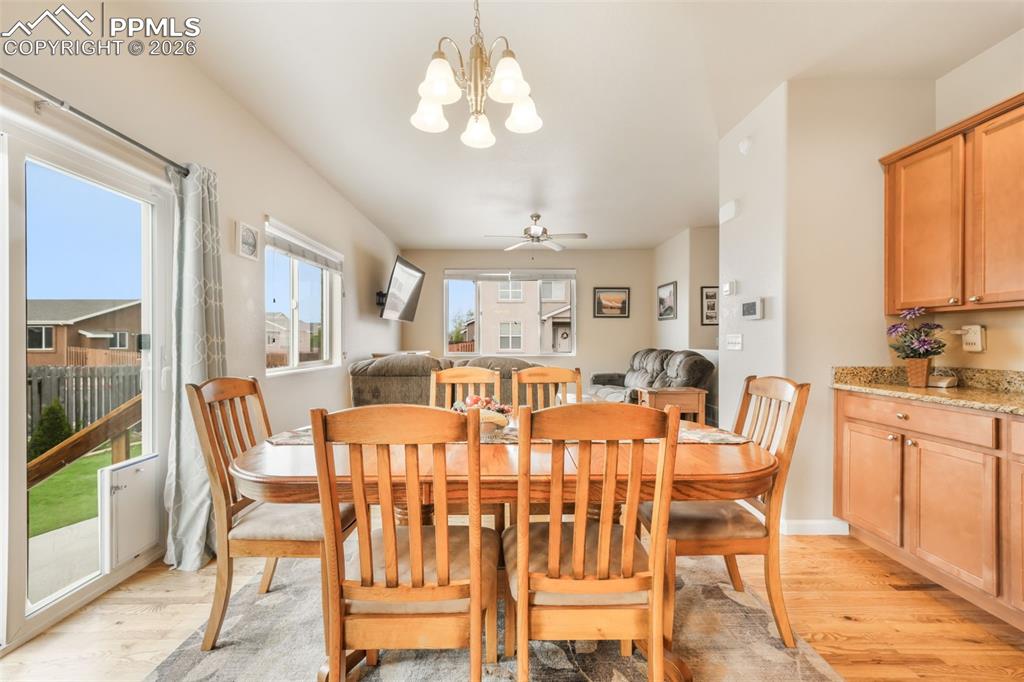 Image 10 of 50: Open-concept living area featuring wood-finish flooring, a ceiling fan with