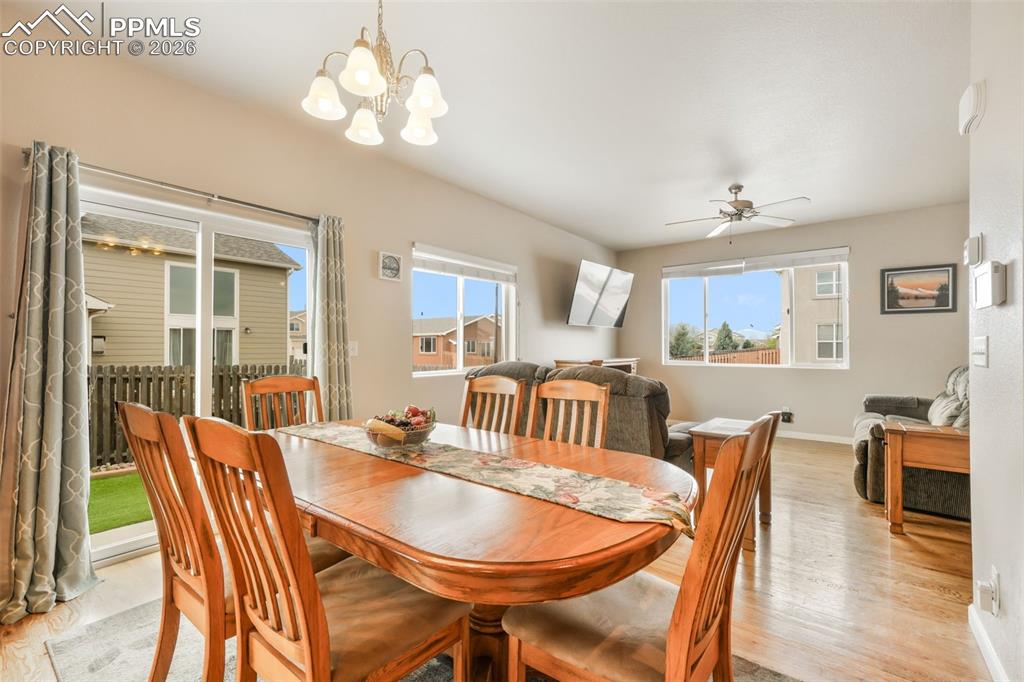Image 11 of 50: Living area featuring wood-finish flooring, a ceiling fan, and a built-in m
