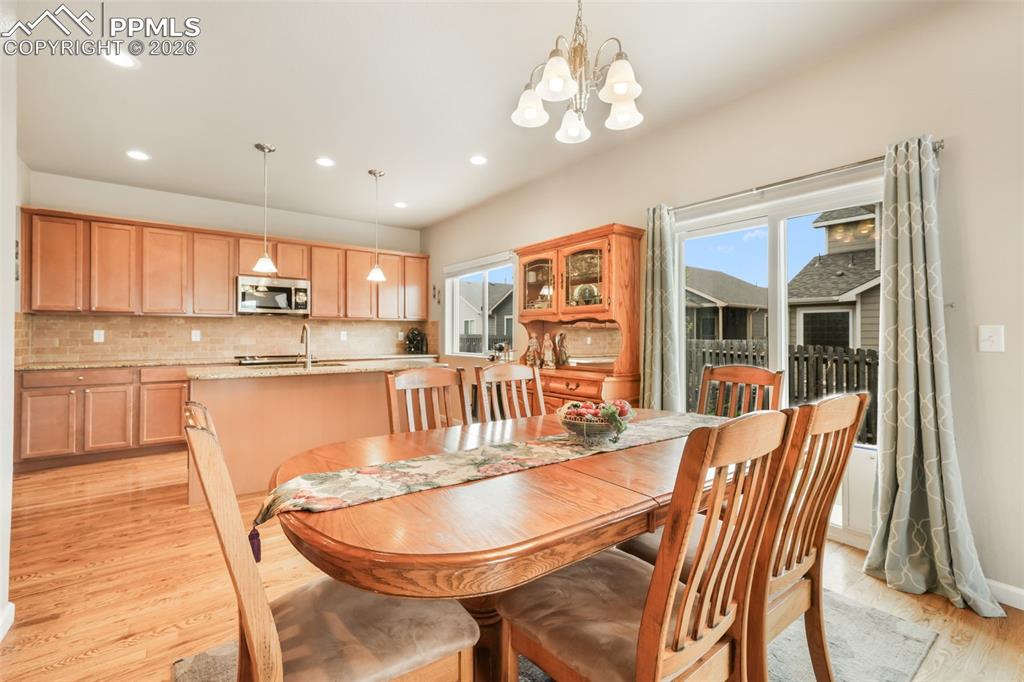 Image 12 of 50: Bright open-concept living area featuring wood-finish flooring, a ceiling f