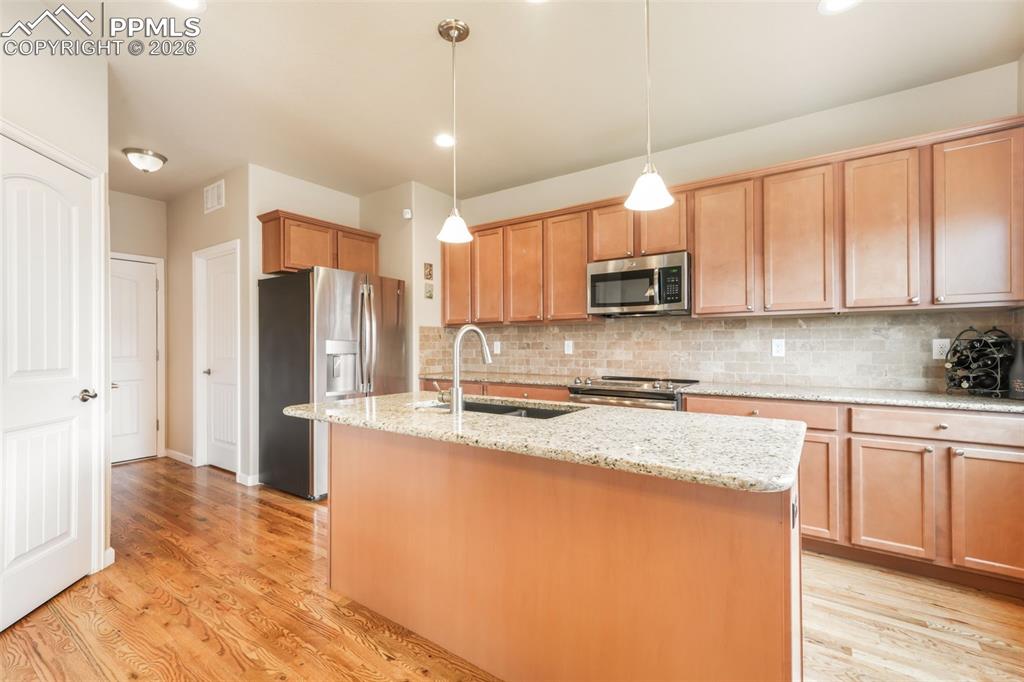 Image 14 of 50: Open-concept dining and living area featuring wood-finish flooring, a ceili