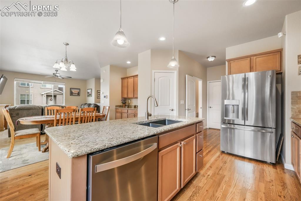 Image 15 of 50: Open-concept kitchen and dining area featuring wood-finish flooring, recess