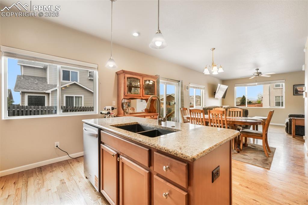 Image 17 of 50: Kitchen featuring a central island with a light-toned countertop, wood-fini