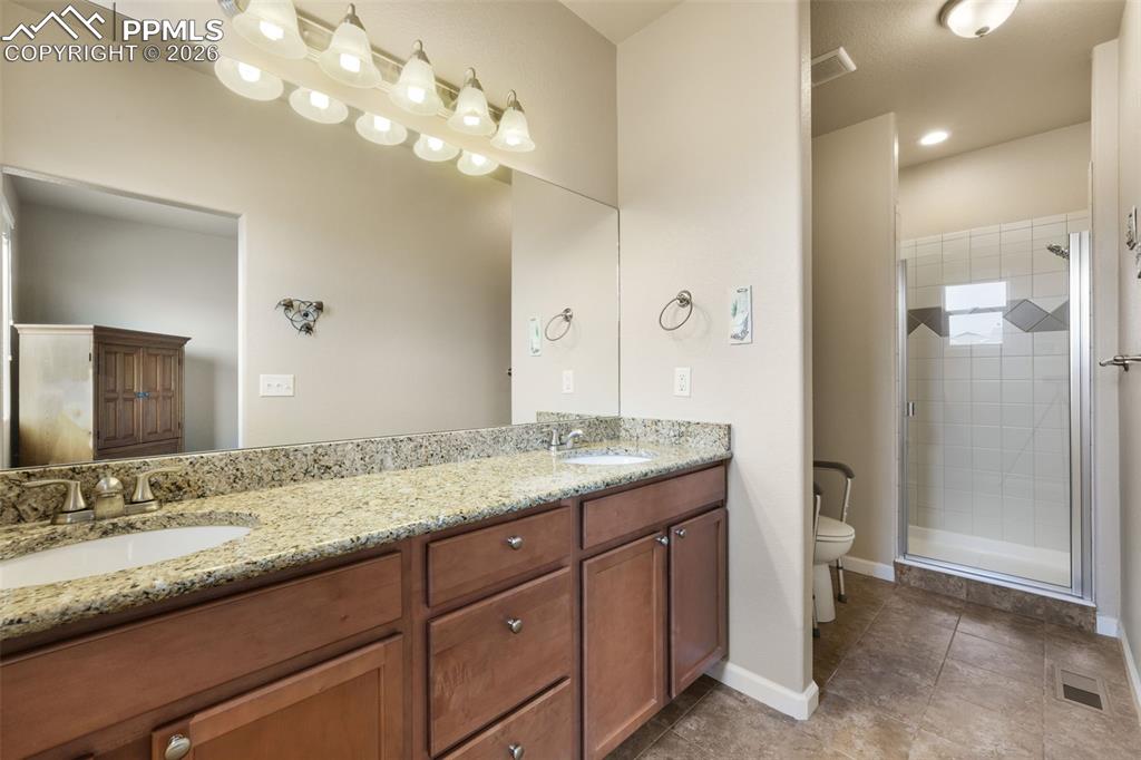 Image 24 of 50: Carpeted bedroom featuring a ceiling fan with light fixture, ample natural 