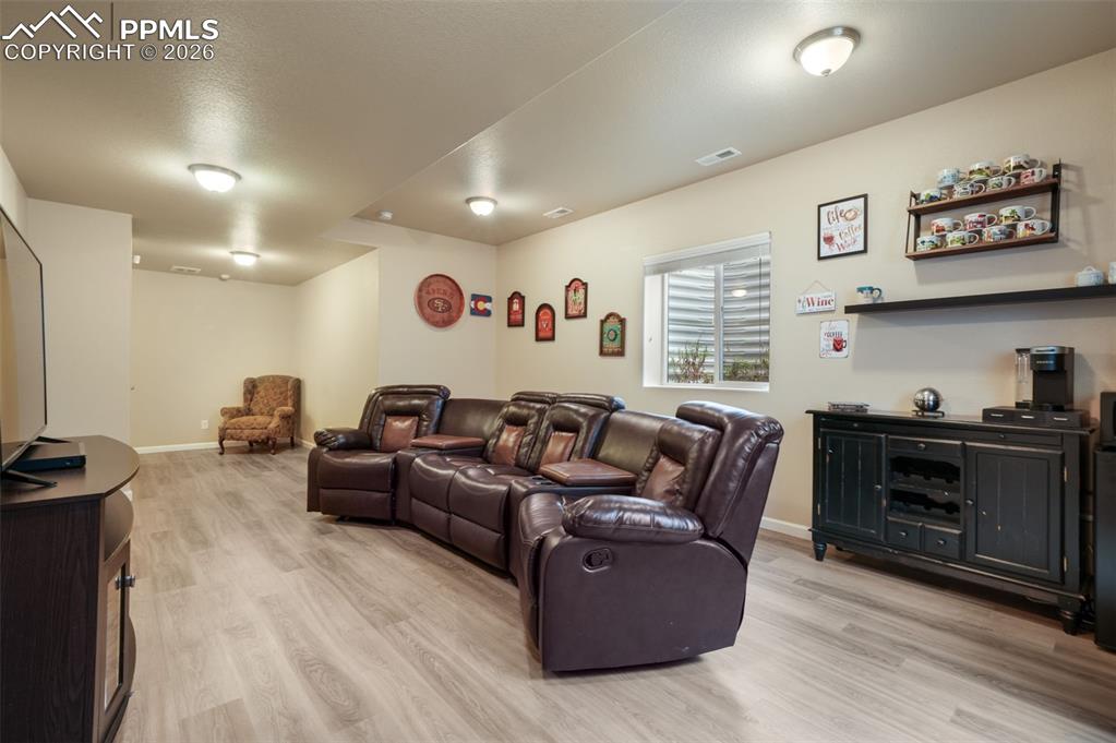 Image 30 of 50: Versatile lower-level room featuring light wood-finish flooring and neutral