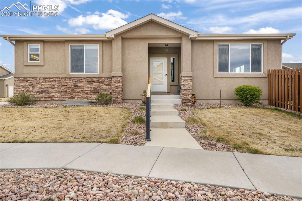Image 4 of 50: Stucco exterior with an attached garage and concrete driveway
