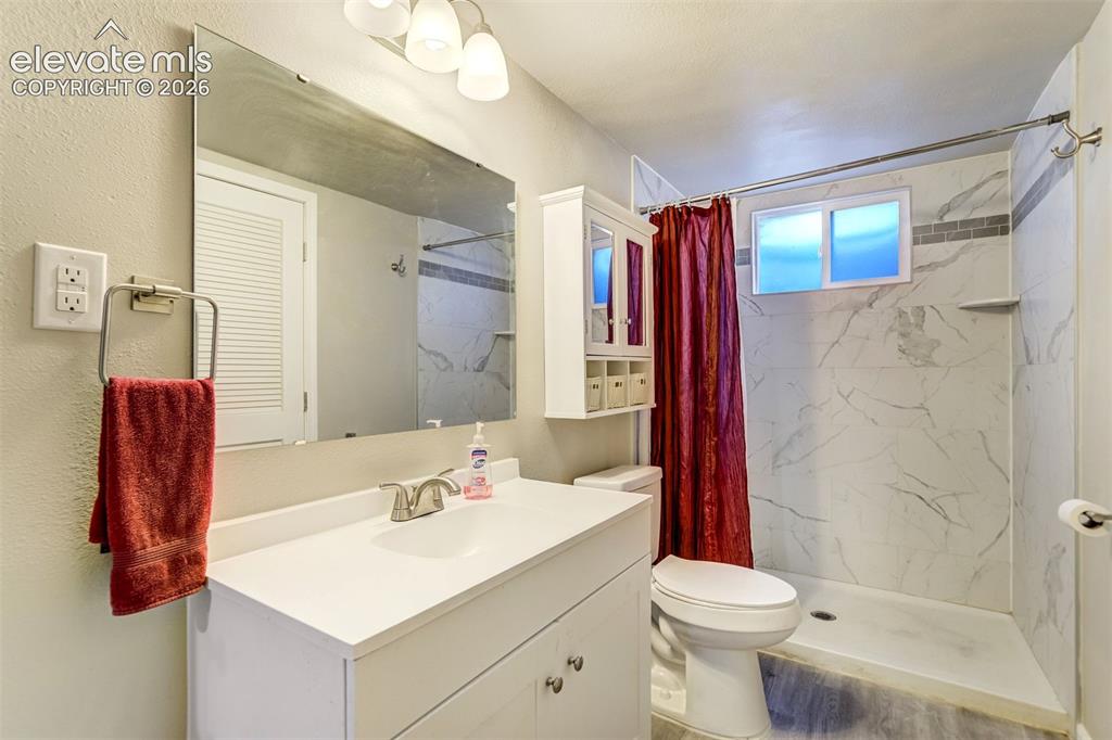 Image 33 of 45: Beautifully updated basement bath, leads to laundry/utility room.