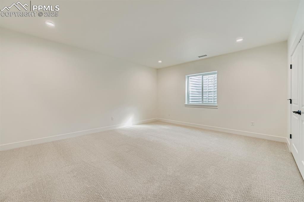 Image 22 of 27: Empty room featuring light colored carpet and recessed lighting