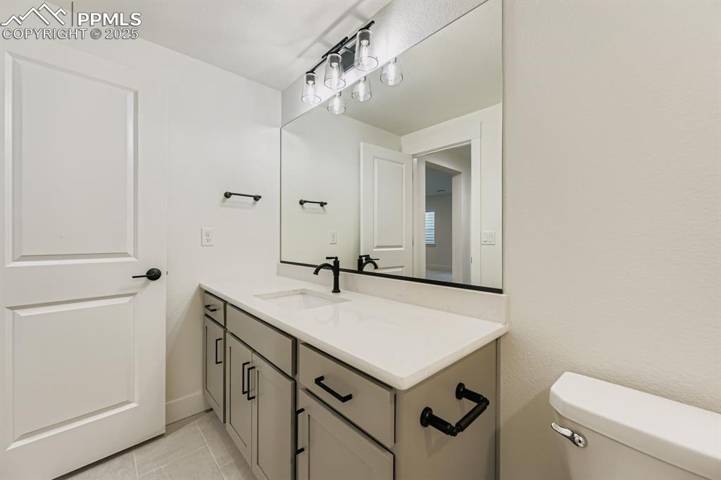 Image 24 of 27: Bathroom with vanity and light tile patterned flooring