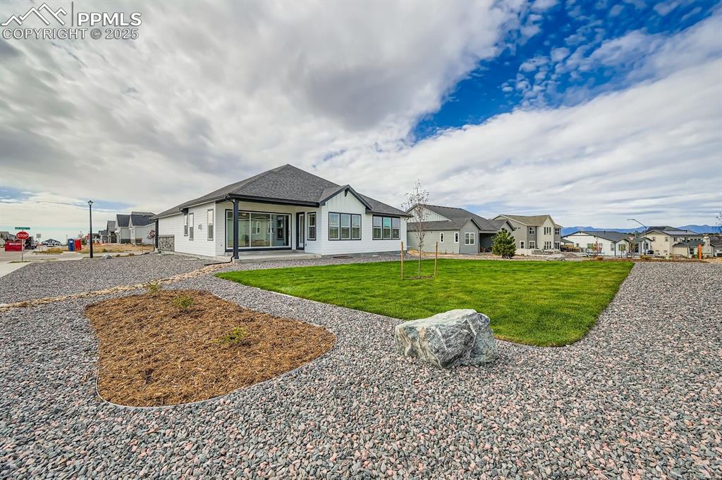 Image 27 of 27: Rear view of property with a lawn, a patio area, a shingled roof, and a res