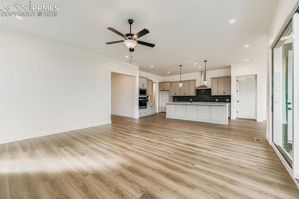 Image 7 of 27: Unfurnished living room featuring light wood-style floors, recessed lightin