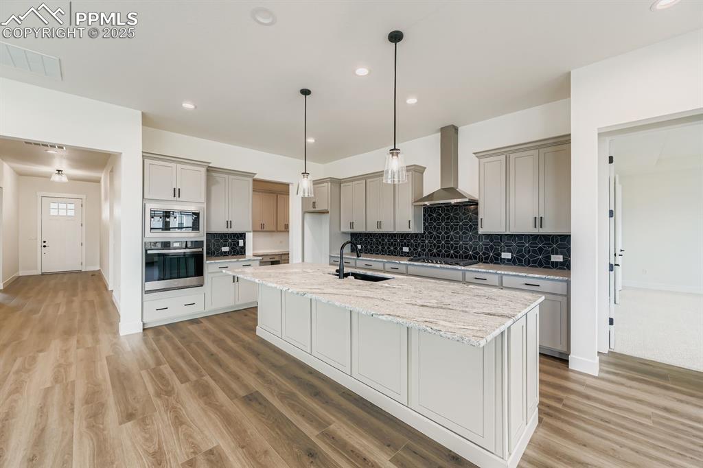 Image 9 of 27: Kitchen featuring hanging light fixtures, appliances with stainless steel f