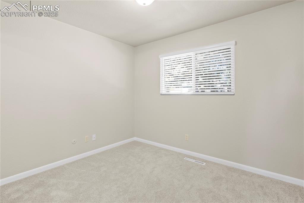 Image 11 of 35: Empty room with light colored carpet and baseboards