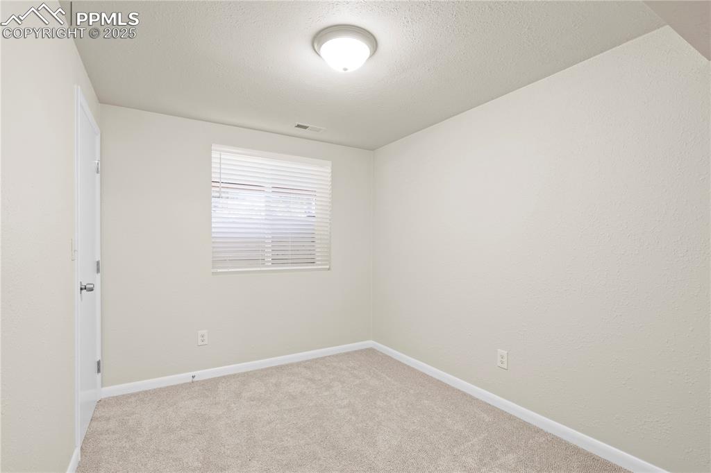 Image 18 of 35: Empty room featuring light carpet and a textured ceiling