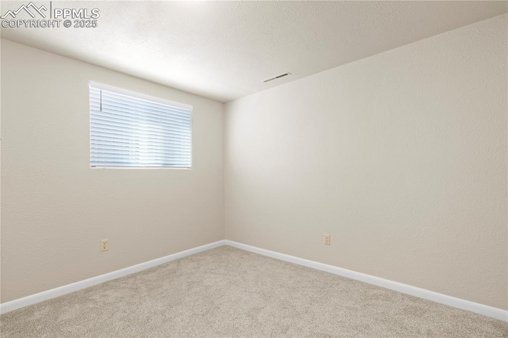 Image 21 of 35: Carpeted spare room with baseboards and a textured wall