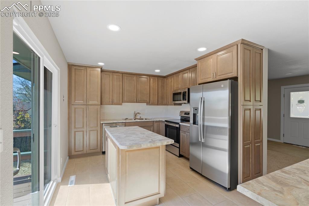 Image 3 of 35: Kitchen featuring appliances with stainless steel finishes, plenty of natur
