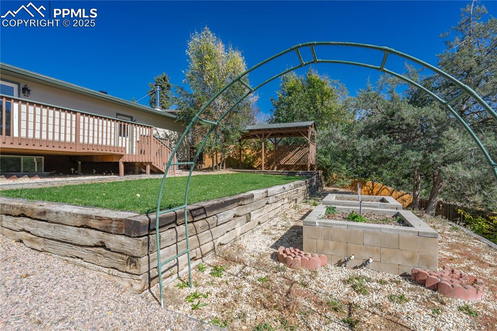 Image 33 of 35: View of yard featuring a vegetable garden, a wooden deck, and stairway