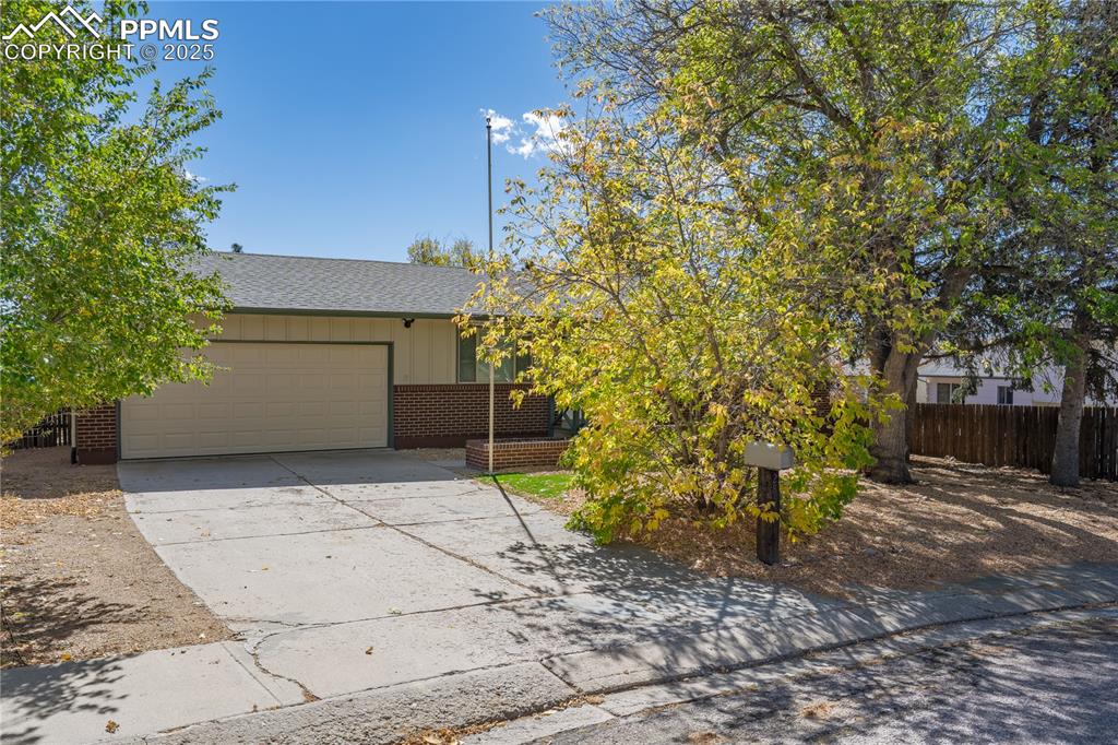 Image 35 of 35: View of front of property with driveway, brick siding, a garage, a shingled