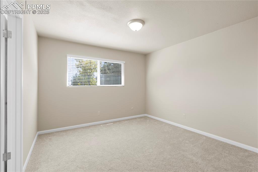 Image 9 of 35: Spare room featuring light carpet and baseboards