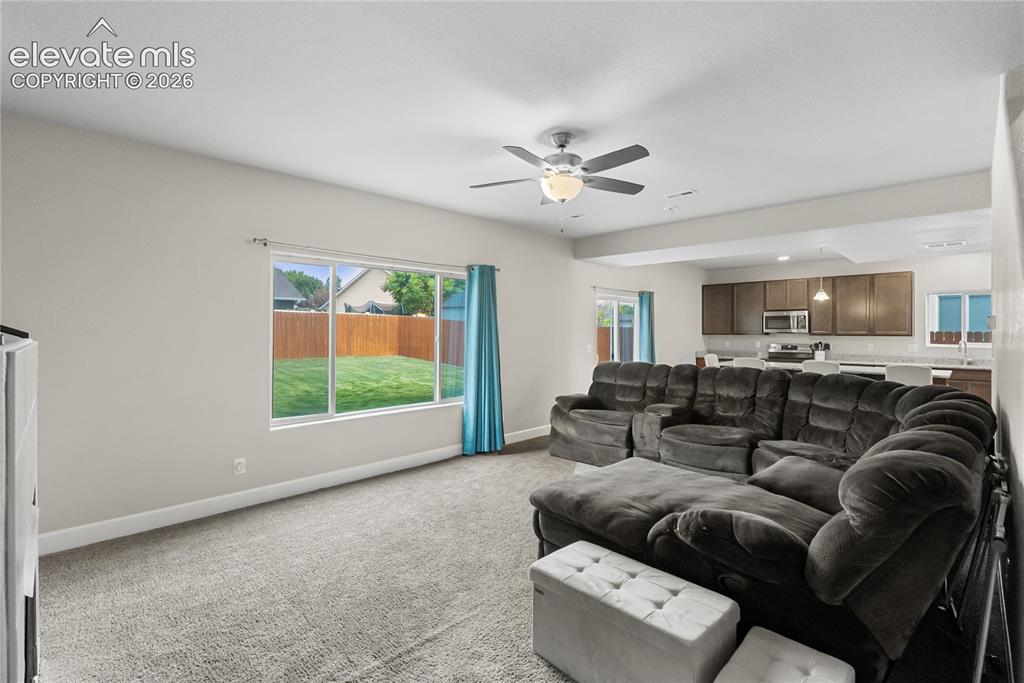 Image 18 of 42: Open-concept living space featuring a window overlooking the backyard, a ce