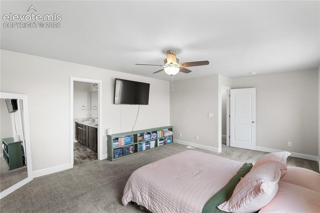 Image 26 of 42: Spacious room featuring neutral wall tones, grey carpet, and a ceiling fan 