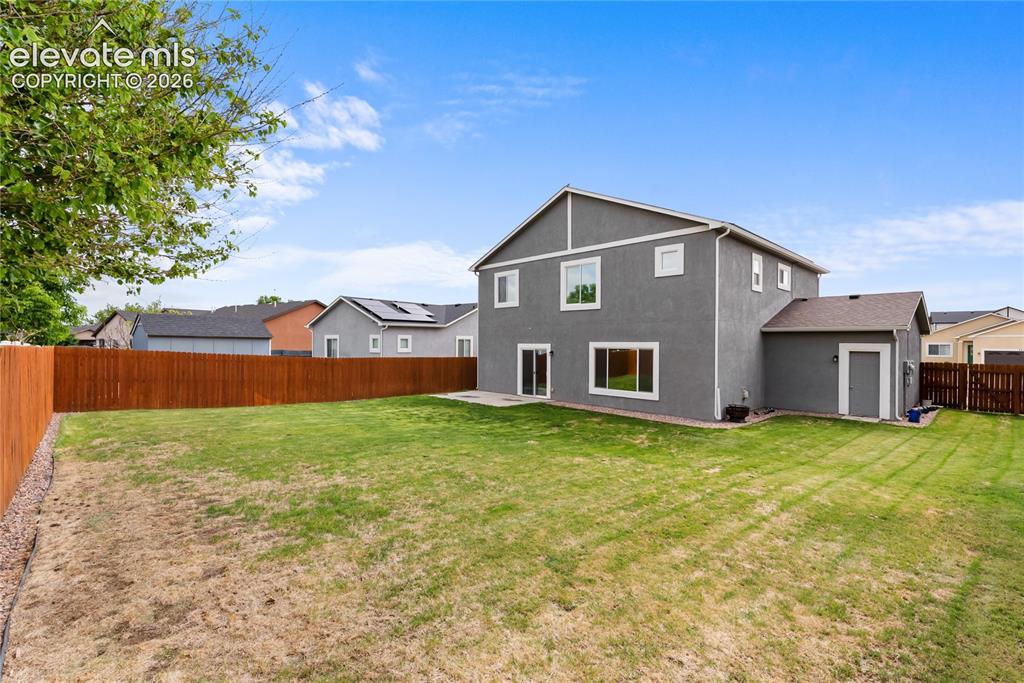 Image 32 of 42: Expansive backyard featuring a manicured lawn and a full privacy fence