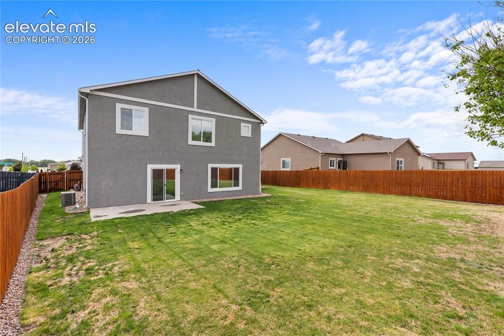 Image 33 of 42: Expansive grass lawn with a full privacy fence