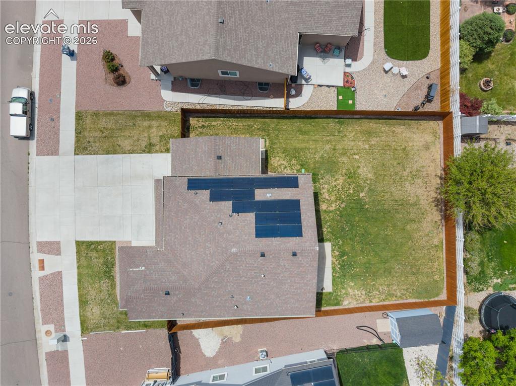 Image 34 of 42: Expansive property featuring a large concrete driveway, a privacy fence enc