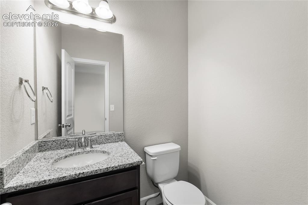 Image 7 of 42: Bathroom vanity with a granite countertop, undermount sink, and brushed nic