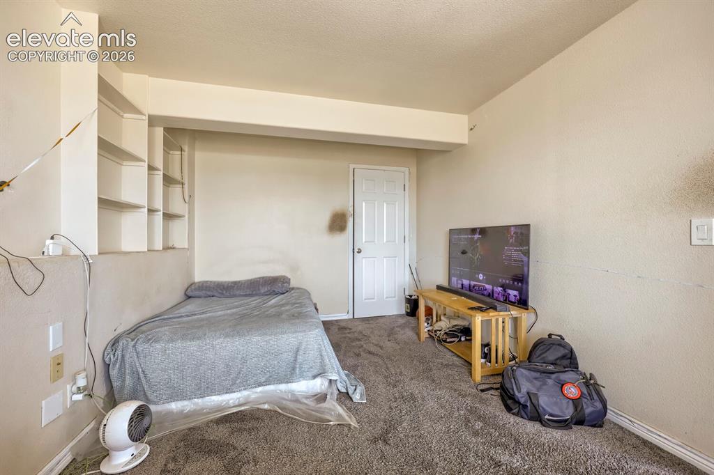 Image 13 of 17: Built-in shelving, white painted interior door, light-colored walls, textur