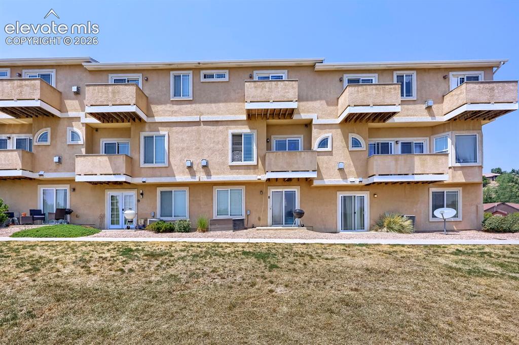 Image 17 of 17: Multi-story stucco exterior featuring multiple balconies and ground-level p