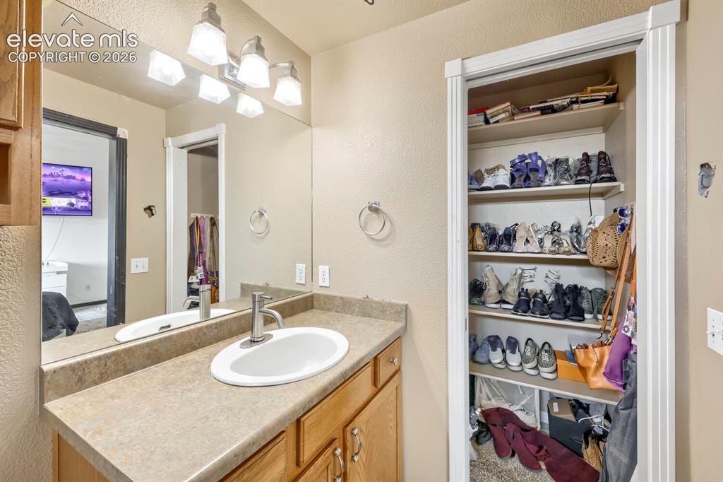 Image 8 of 17: Vanity with an integrated sink and brushed nickel faucet, large wall mirror