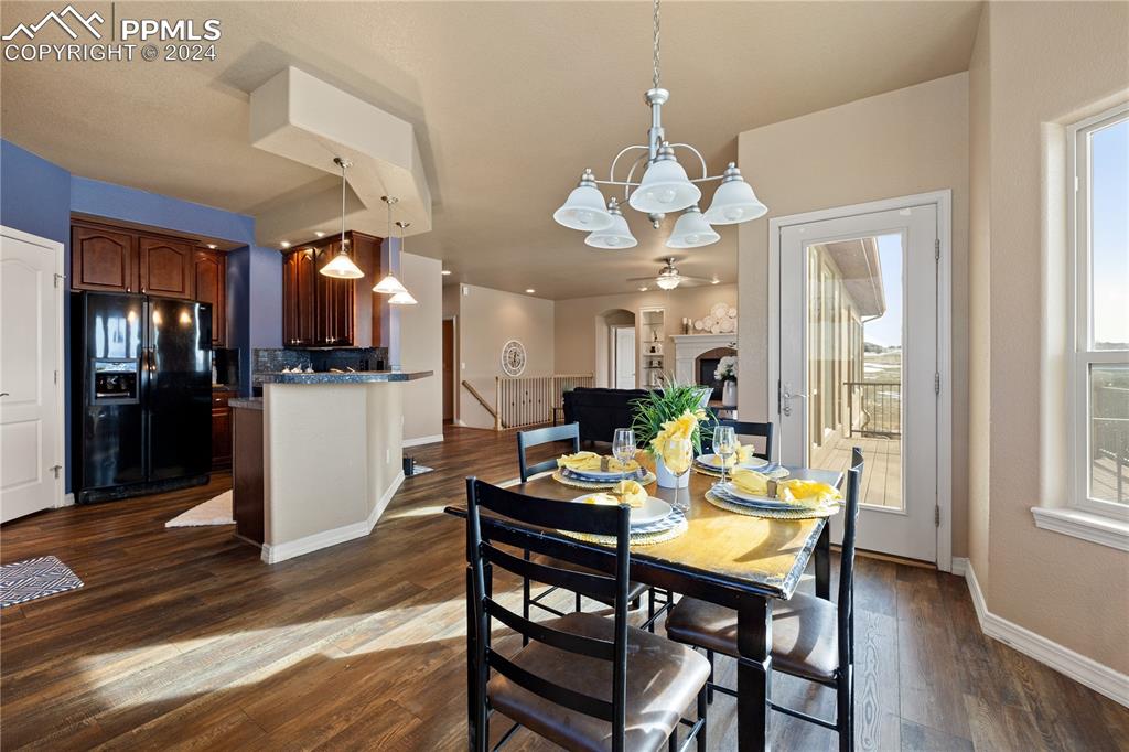 Image 10 of 48: Dining room with ceiling fan with notable chandelier and hardwood / wood-st