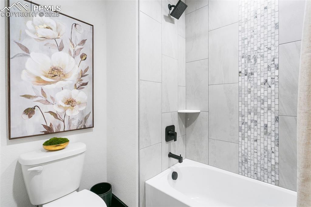 Image 23 of 23: Full bath featuring tub / shower combination and toilet