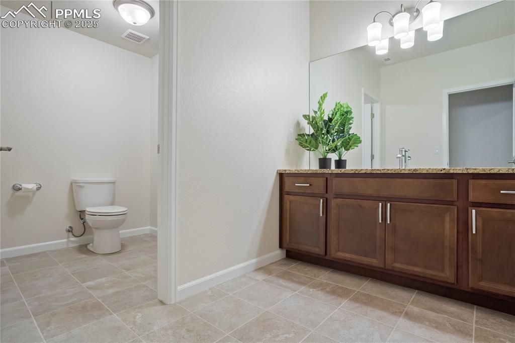 Image 37 of 50: Lower level full bathroom with tile floors, and granite topped vanity